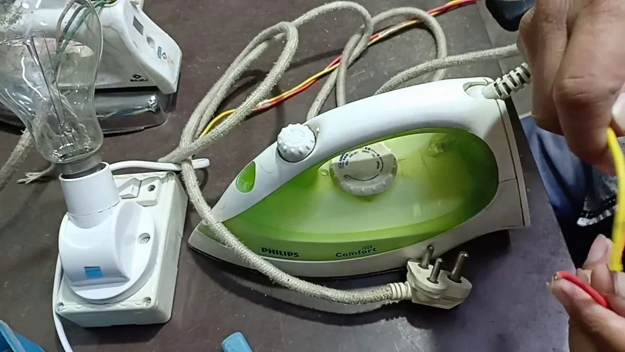 Steam iron with exposed wiring during repair