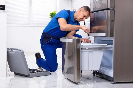 Technician repairing a refrigerator